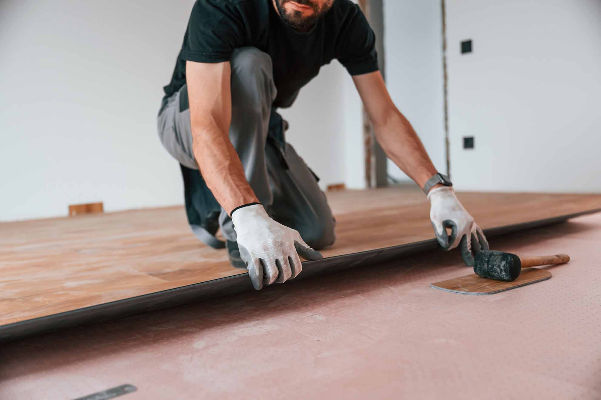 Man installing laminate flooring.